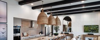 the kitchen and dining area of a house with exposed beams